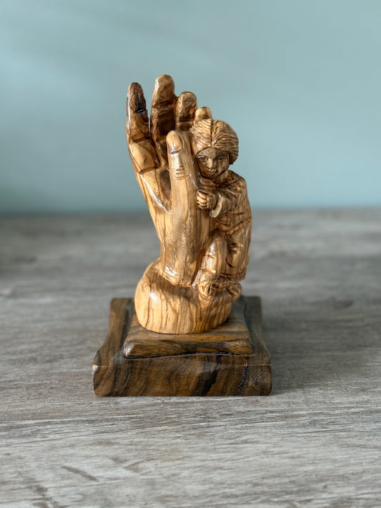 Praying hand with child statue